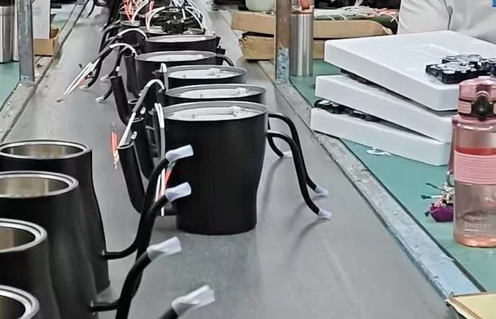 Kettle bodies visible along a factory work line